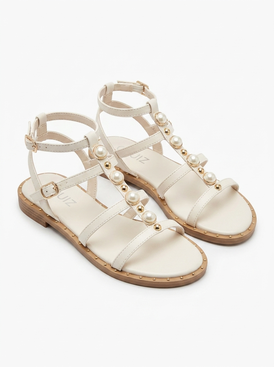 Sandalias con tiras de perlas y tachuelas doradas