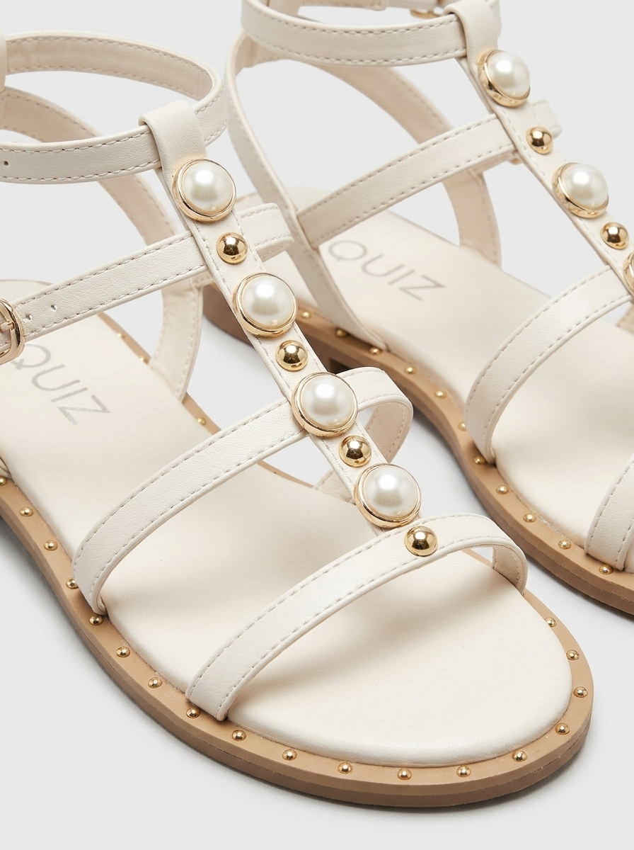 Sandalias con tiras de perlas y tachuelas doradas